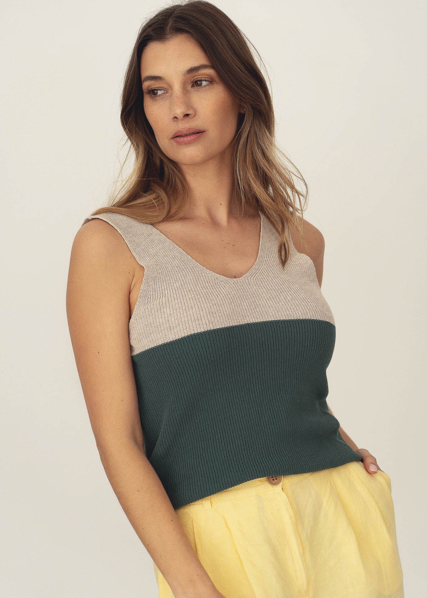 Naz women's summer knit top in green and beige. Features a deep v-neckline. Made sustainably in Portugal from recycled fibers. 